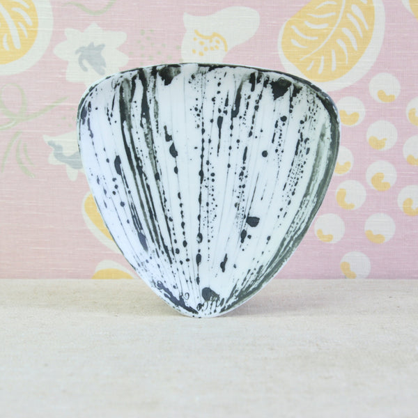 A decorative triangular plate with a white base and black splatter and brushstroke pattern. Design by Susan Parkinson in the spirit of the Bayswater Group and potters Margaret Hine and Nicholas Vergette