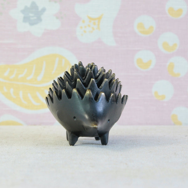Walter Bosse's famous mid-century hedgehog ashtray set, with six individual brass hedgehogs stacked together to form one sculptural figure.