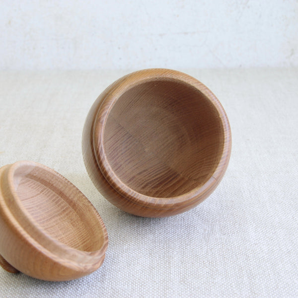 Looking inside a collectible Scandinavian wooden box designed by Erik Höglund for Boda, featuring a tactile acorn-inspired form.