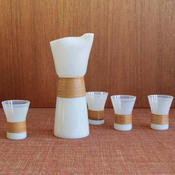 Group shot of a rattan-wrapped Opaline carafe and glasses drinks set designed by Denmarks first Industrial designer Jacob Bang. A fantastic example of Danish mid-century Modern design.