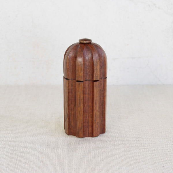 Wooden vintage Dansk pepper mill with eight carved grooves by Jens Quistgaard. Pepper grinder on a light background.