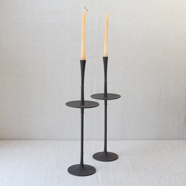 Top down view of a pair of Jens Quistgaard candlesticks fitted with candles. This very tall, slender, organic modern design is by Jens Quistgaard. A most important MidCentury Modern Scandinavian designer than did much to popularise Nordic Modernism in the USA in the twentieth century.