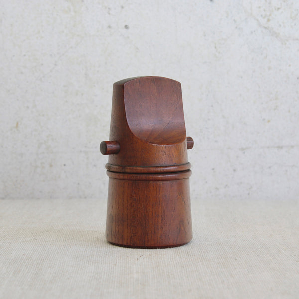 This elegant mid-century teak “flathead” pepper mill designed by Jens Quistgaard reflects the refined modernism of Dansk Designs.