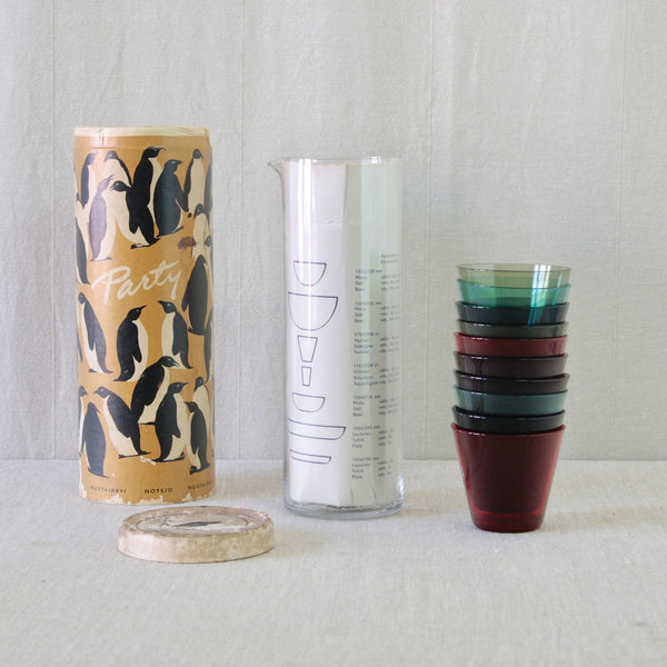 Kaj Franck Party-set for Nuutajärvi Notsjö, circa 1955, with clear pitcher, ten colourful glasses and original penguin-covered packaging.
