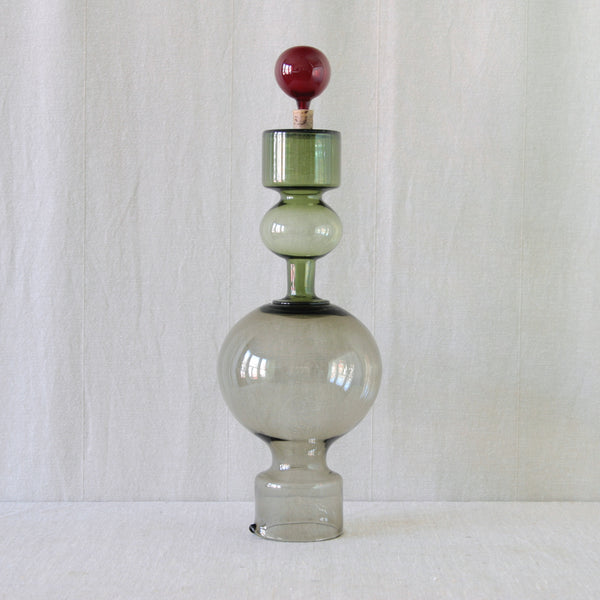 A playful artistic image showing a vintage collectable Kaj Franck Kremlin Kellot juice set for Nuutajärvi, with contrasting coloured components that have been stacked unusually. 