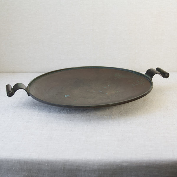 Top down view of a large circular charger or platter with two carrying handles, designed by Einar & Sune Bäckström, around 1934.