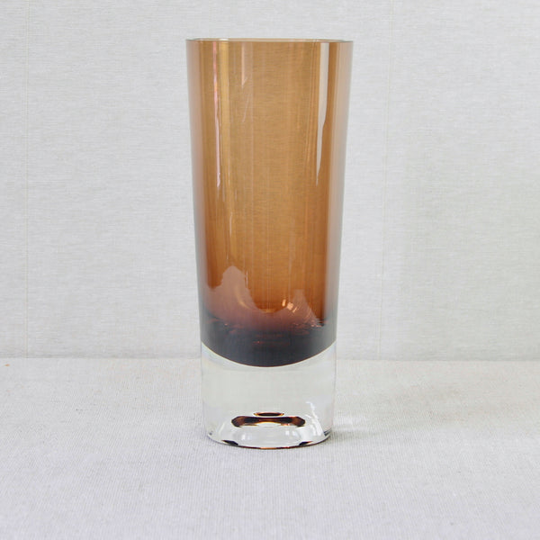 A 26cm tall amber and clear cased-glass model KF267 vase, designed by Kaj Franck for Nuutajärvi Notsjö, Finland. The base’s foot or base holds has an optical effect which makes the design seen light and to float.