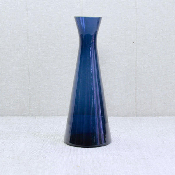 A conical geometric indigo blue glass vase or wine carafe designed by Kaj Franck in 1954 for Nuutajärvi Notsjö, Finland.This sleek and richly coloured collectible mid-century modern design belongs to the ‘1541’ series.