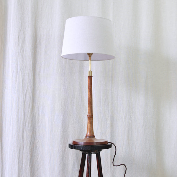 Side view of Esben Klint's Model 301/27 for Le Klint, showing the continuous silhouette of the turned ash base and gently tapered stem.