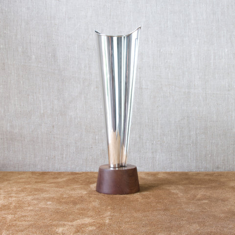 Profile image of a large Modernist solid silver vase mounted atop a teak base designed by Tapio Wirkkala in 1960.