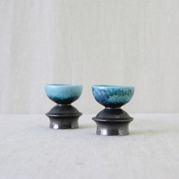 Liisa Hallamaa stoneware candleholders with richly mottled blue glaze, moving between deep cobalt and brilliant turquoise.