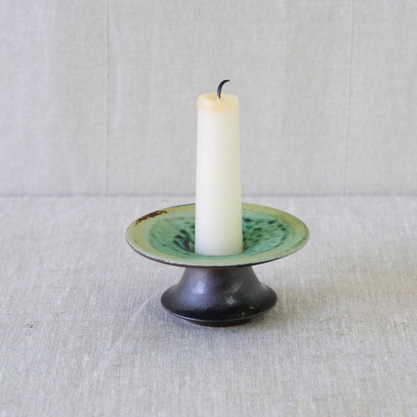 Chocolate-brown stoneware candleholder by Liisa Hallamaa for Arabia, contrasting an earthy exterior with a brilliantly green coloured interior.