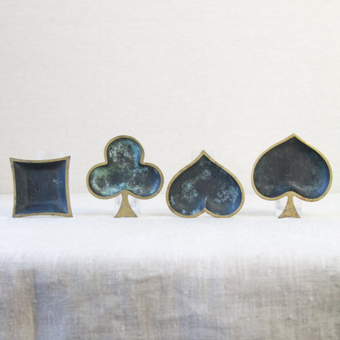 Rare collection of modernist brass ashtrays, each shaped like a playing card suit, representing mid-20th-century European metalware craftsmanship.