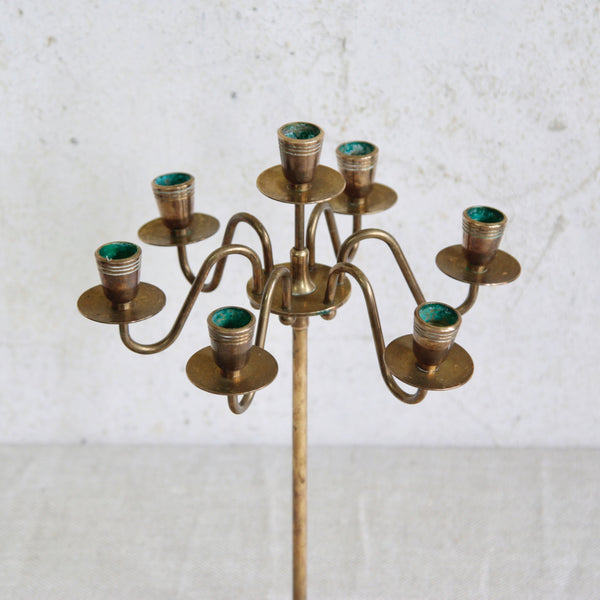 Top down shot of a Swedish brass candelabra, mid-century 1950s design with seven arms, perfect for creating a warm, elegant atmosphere.