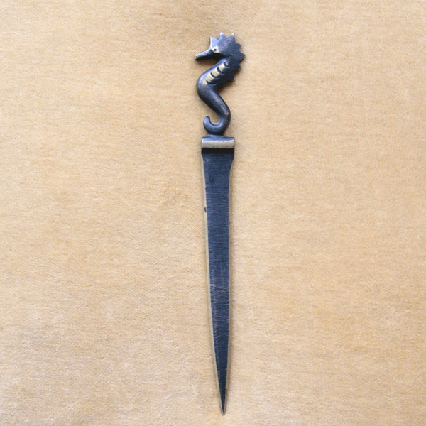 Decorative letter opener with seahorse design on a golden yellow background. Modernist Walter Bosse seahorse letter opener, made by Herta Baller, Austrian mid-century brass collectible.