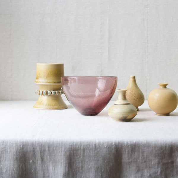 1940's Organic Modernist Finnish glass bowl by Gunnel Nyman, surrounded by yellow studio pottery vases