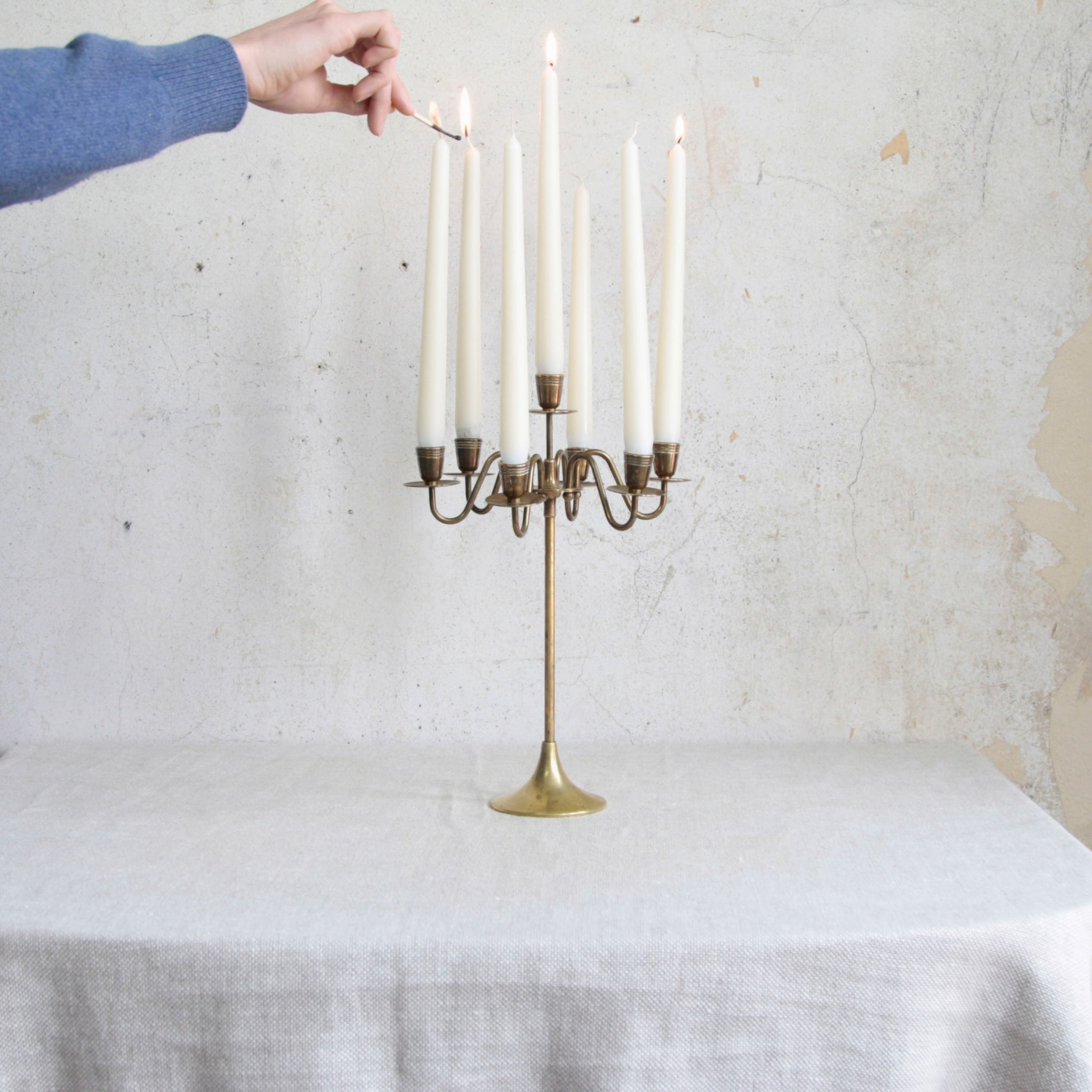 Head on lead shot of a vintage Swedish seven-candle brass candelabra, 1950s mid-century Nordic design with timeless charm.