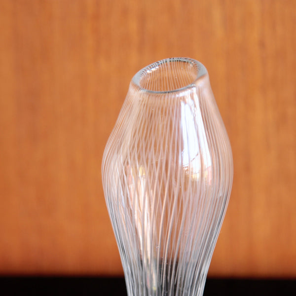 Clear glass vase with ribbed design on a wooden surface. Rare signed Tapio Wirkkala vase for Iittala, Finland, Varsanjalka.