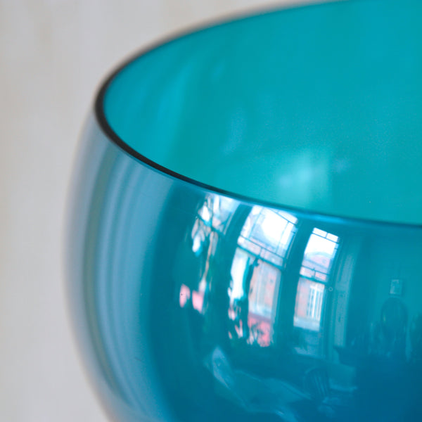 Close-up of Nanny Still turquoise dessert bowl with clear glass stem, a sculptural example of Finnish mid-century tableware from the Harlekiini series.
