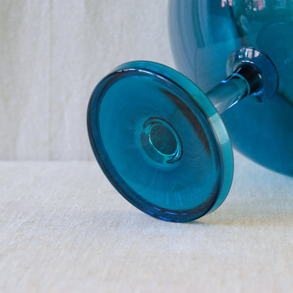 Close-up of the turquoise-blue glass foot of Nanny Still’s Harlekiini footed serving bowl.
