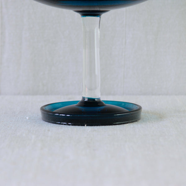 Close-up of Nanny Still’s hand-blown Harlekiini glass bowl, showing the transition between the turquoise foot and clear stem.
