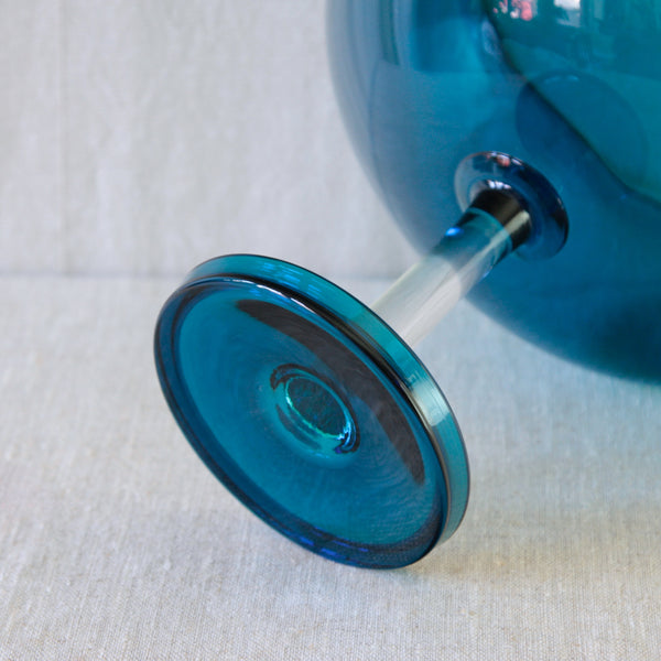 Detail of the clear glass stem and foot beneath a turquoise Nanny Still Harlekiini bowl, designed for Riihimäki in 1958.