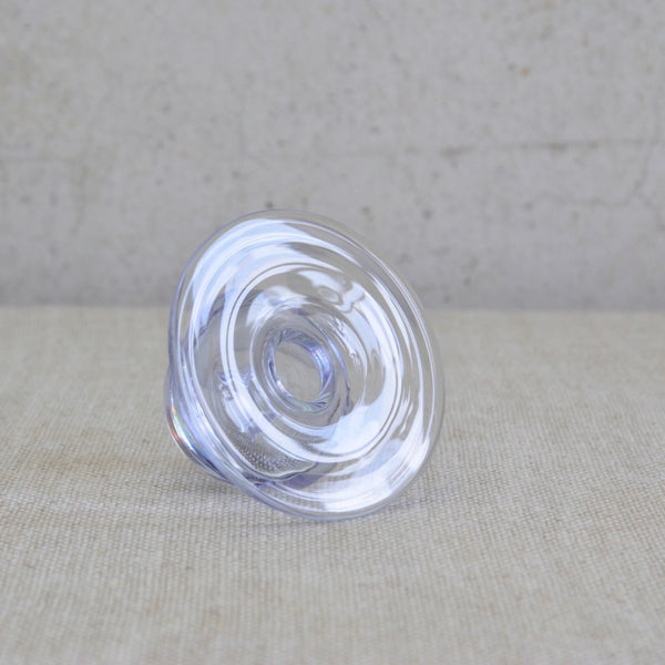 Head on image of the ripples in the large glass rim on a 1960s Scandinavian art object called Saturnus, designed by Nanny Still. The neodymium glass changes colour from lilac to sky blue depending on the light.