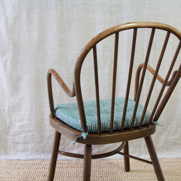 A collectible Niels Eilersen Windsor chair with a steam-bent wood seat, blending craftsmanship and sophistication effortlessly.