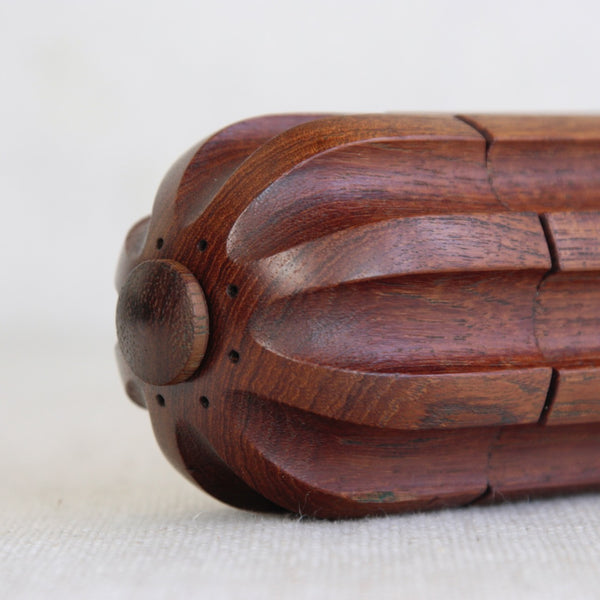 Close-up of a wooden pepper grinder with built in salt shaker. Bullet-shaped Danish pepper mill by Jens Quistgaard for Dansk Designs.