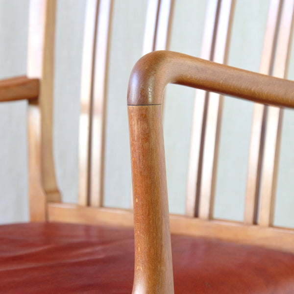 Close-up detail of the arm on a vintage Danish carver by Ole Wanscher for Fritz Hansen, combining traditional spindle-back construction with light Modernist proportions.