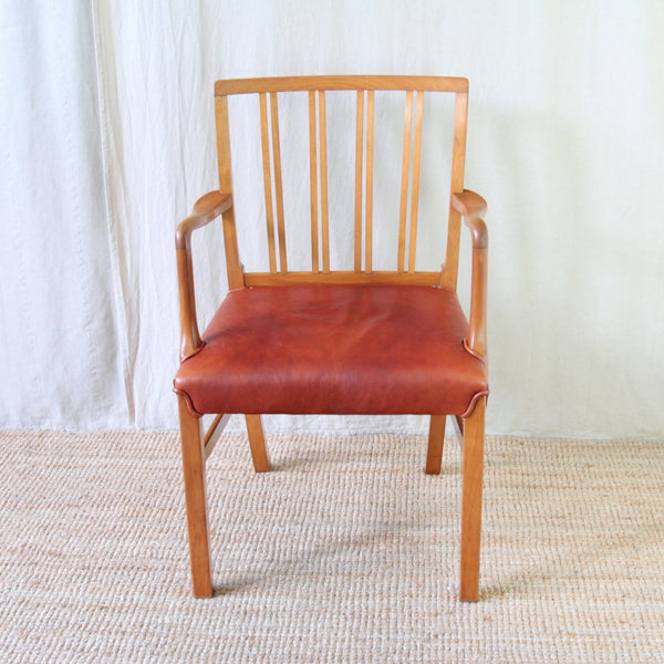Top down front view of a 1940s Ole Wanscher armchair showing broad curved armrests and wide generous seat.