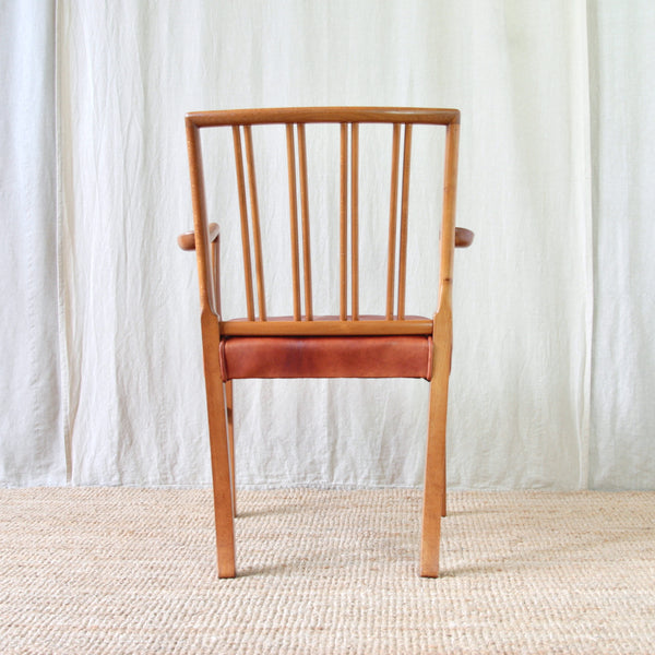 Back view Ole Wanscher 1675 carver chair showing the warm beech frame, rich red leather upholstery and elegant open spindle back.