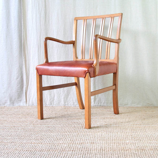 Profile image Ole Wanscher Model 1675 carver chair, designed for Fritz Hansen in 1942, with a honey-yellow beech frame and deep red leather seat.
