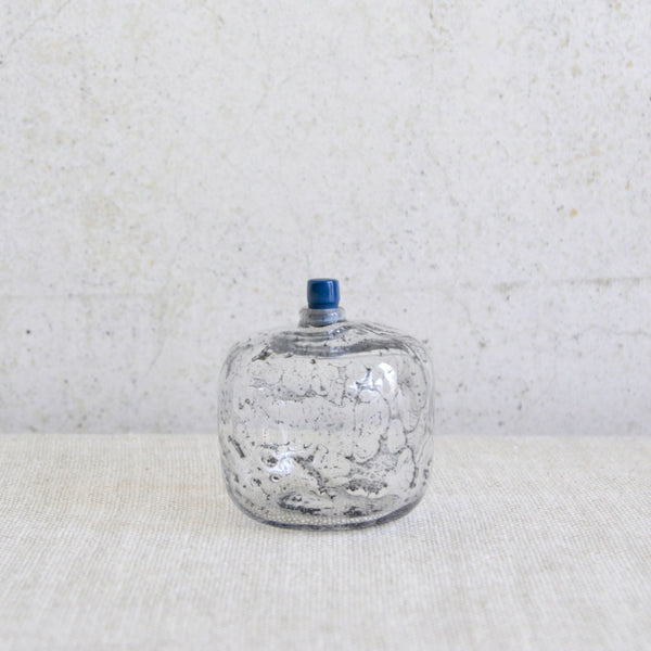 Scandinavian art glass bottle by Ingeborg Lundin with textured bubbly surface and blue stopper.