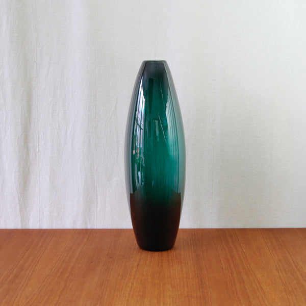 Colossal Per Lütken torpedo vase in dark green glass, with an elongated sculptural silhouette and dramatic architectural scale.