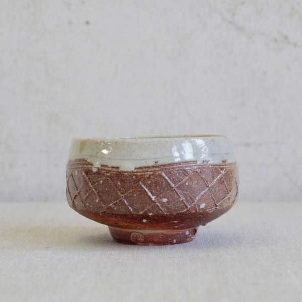 Wheel-thrown chawan by Phil Rogers showing reddish stoneware body and salt-glazed exterior surface. Large and expressive British studio pottery.
