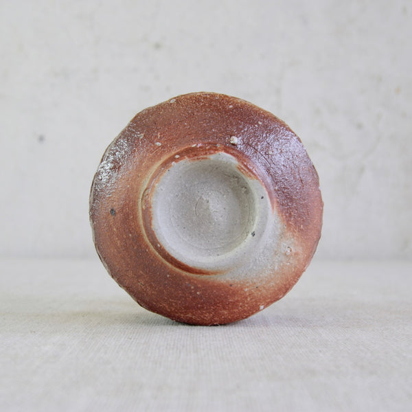 Underside of a wood-fired stoneware chawan by Phil Rogers demonstrating subtle natural ash effects on the surface.