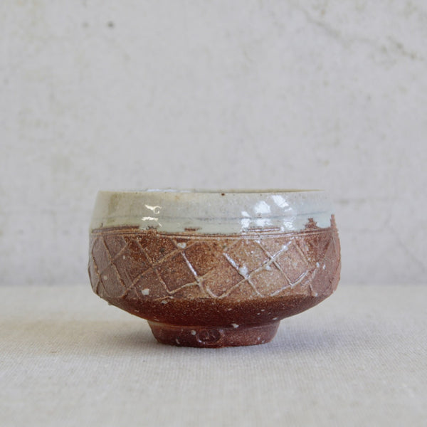 Decorative stoneware tea bowl by Phil Rogers featuring thick white nuka glaze internally and spilling out around the rim. Wood-fired British studio ceramics.
