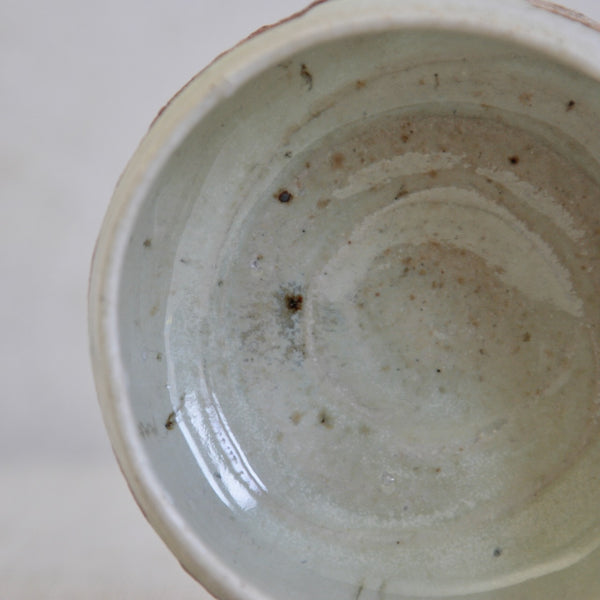 Close-up of Phil Rogers stoneware bowl showing the nuka glaze and areas where ash has landed on the glaze during wood firing.