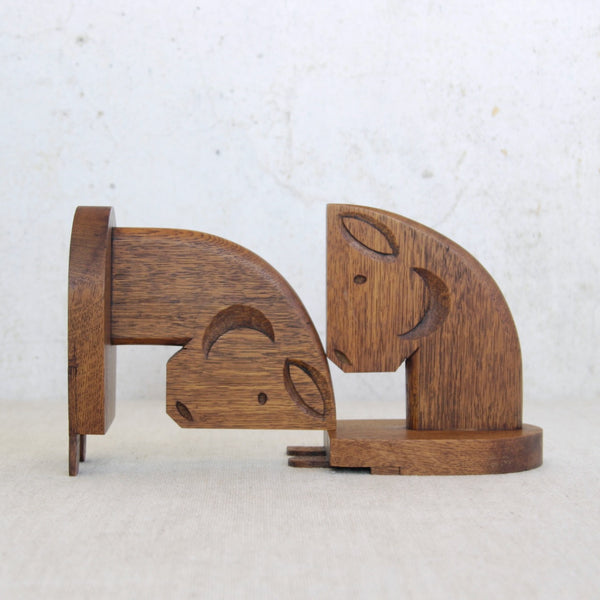Wooden horse-shaped bookends on a light gray background. These hand-carved solid oak horse head bookends were handmade in England circa 1950. They showcase sculptural mid-century craftsmanship.