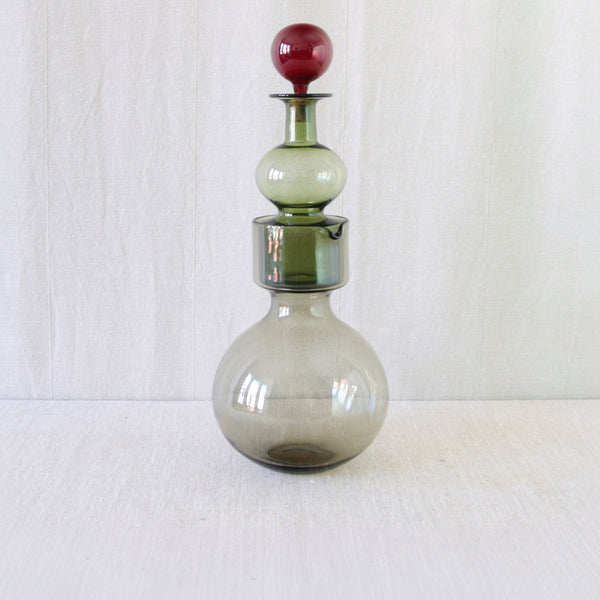 Lead image Kaj Franck Kremlin Kellot (Kremlin Bells) decanter and pitcher, designed for Nuutajärvi Notsjö in 1957, in smoke-grey, bottle-green and ruby-red glass. For sale in the UK from Nordic design gallery Art & Utility.