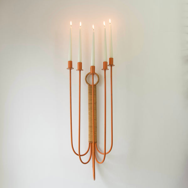 Head on shot of a rare orange wall candelabra by Arthur Umanoff. 5 lit candles are present. Elevate your decor with the timeless sophistication of this monumental wall candelabrum.