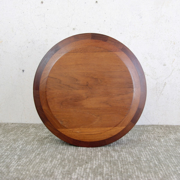 head on shot of the base of a Jens Quistgaard Danish teak bowl for Dansk Designs. A 1960s handmade modernist object showcasing elegant staved construction. Stamped with Dansk's makers mark.