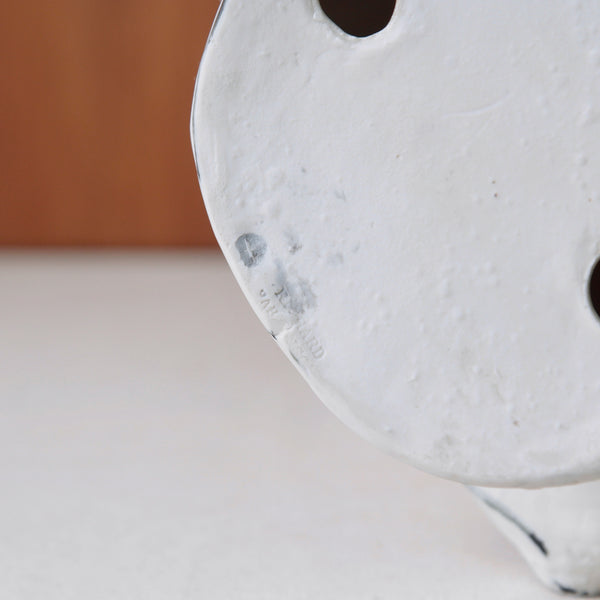 Close up of the makers marks stamped into the base of a vintage Modernist sculpture by Susan Parkinson, model number 67, showing a serene Greek noble in porcelain.