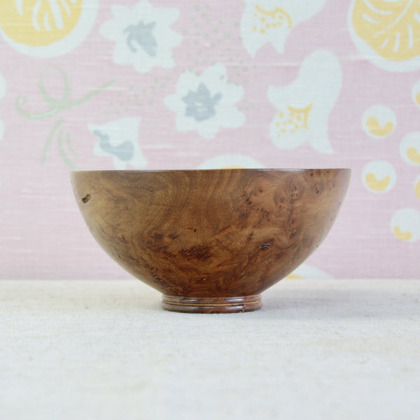 Side profile of Richard Raffan's 1979 elm burr bowl, showing its low rounded form and subtly East Asian character.