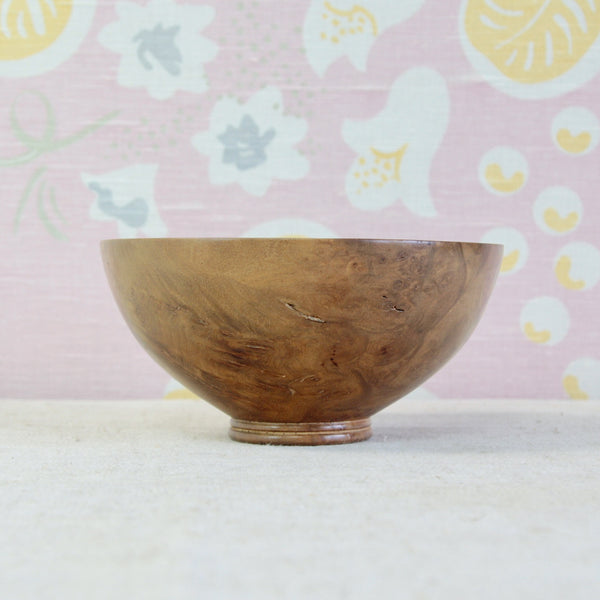 Close view of Richard Raffan's elm burr bowl showing swirling grain, knots and naturally changing patterns across the polished wood surface.