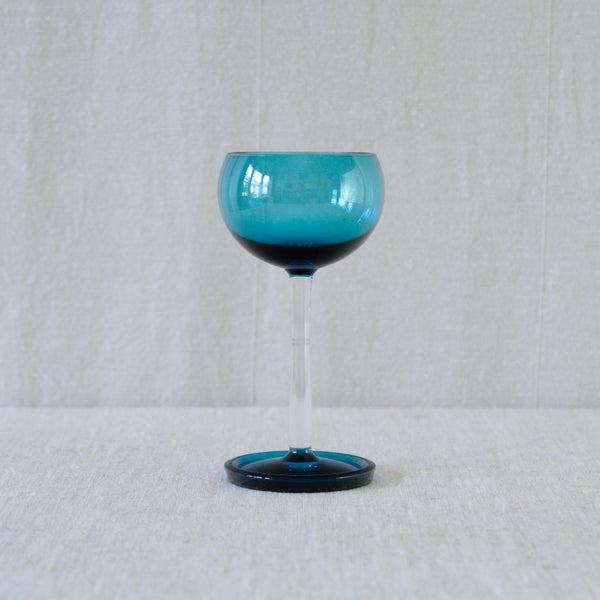 A vintage turquoise blue glass wine glasses from the 'Harlekiini' (Harlequin) series designed by Nanny Still in 1958 for Riihimäen Lasi Oy, Finland.