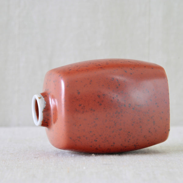Close-up of Nils Thorsson Royal Copenhagen vase with narrow neck and glossy speckled red glaze