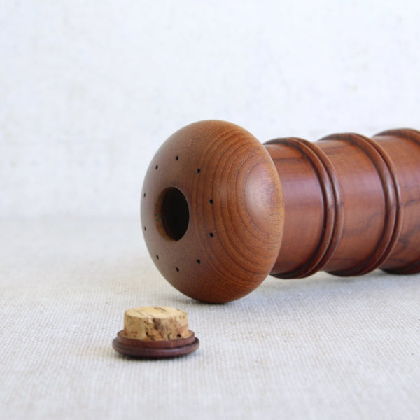 Wooden combination pepper grinder salt shaker on a light background. Iconic Danish modern design by Jens Quistgaard, Model 892.