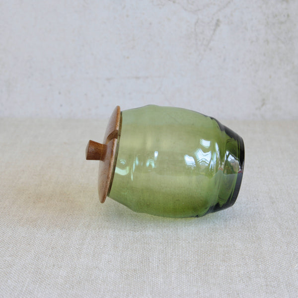 Erik Höglund Boda barrel-form jar combining hand-crafted pine and green glass, illustrating the designer’s sculptural approach to functional objects.